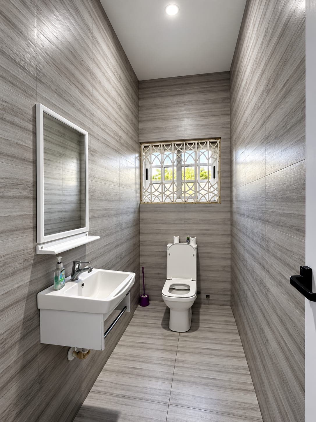 A guest washroom with grey tiled walls, a wall-hung basin and mirror, and a decorative window grille